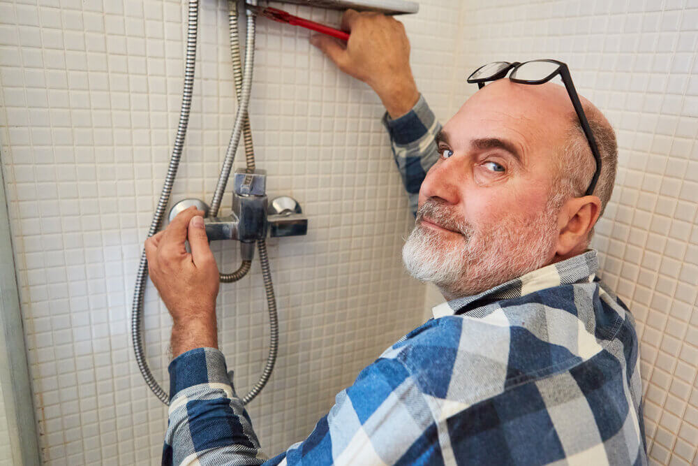 man fixing leaky shower